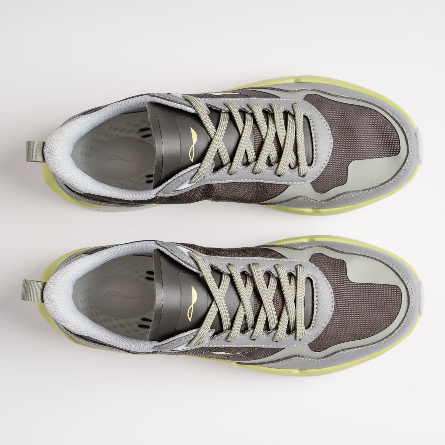 Pair of gray sneakers with white soles on a light gray background