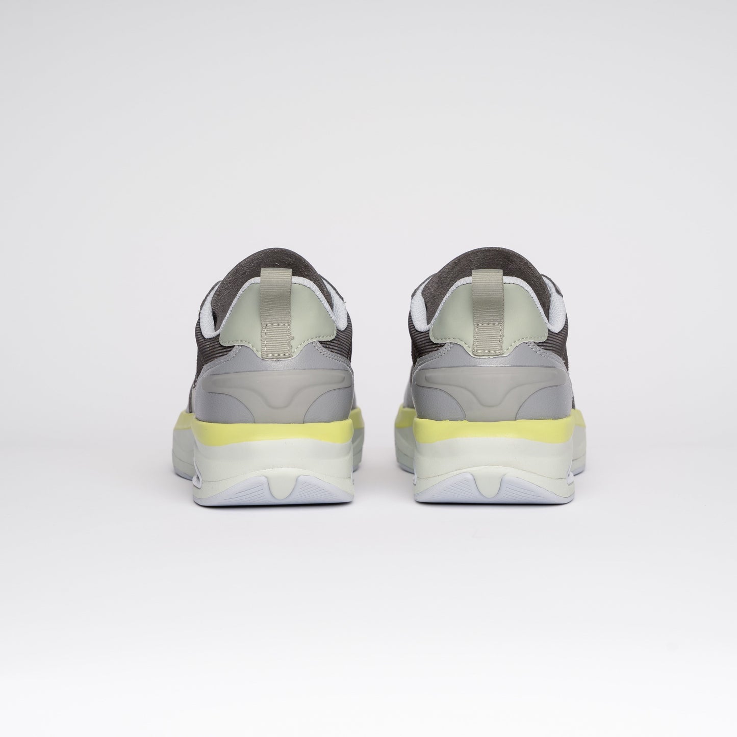 Gray sneakers with yellow accents on a white background