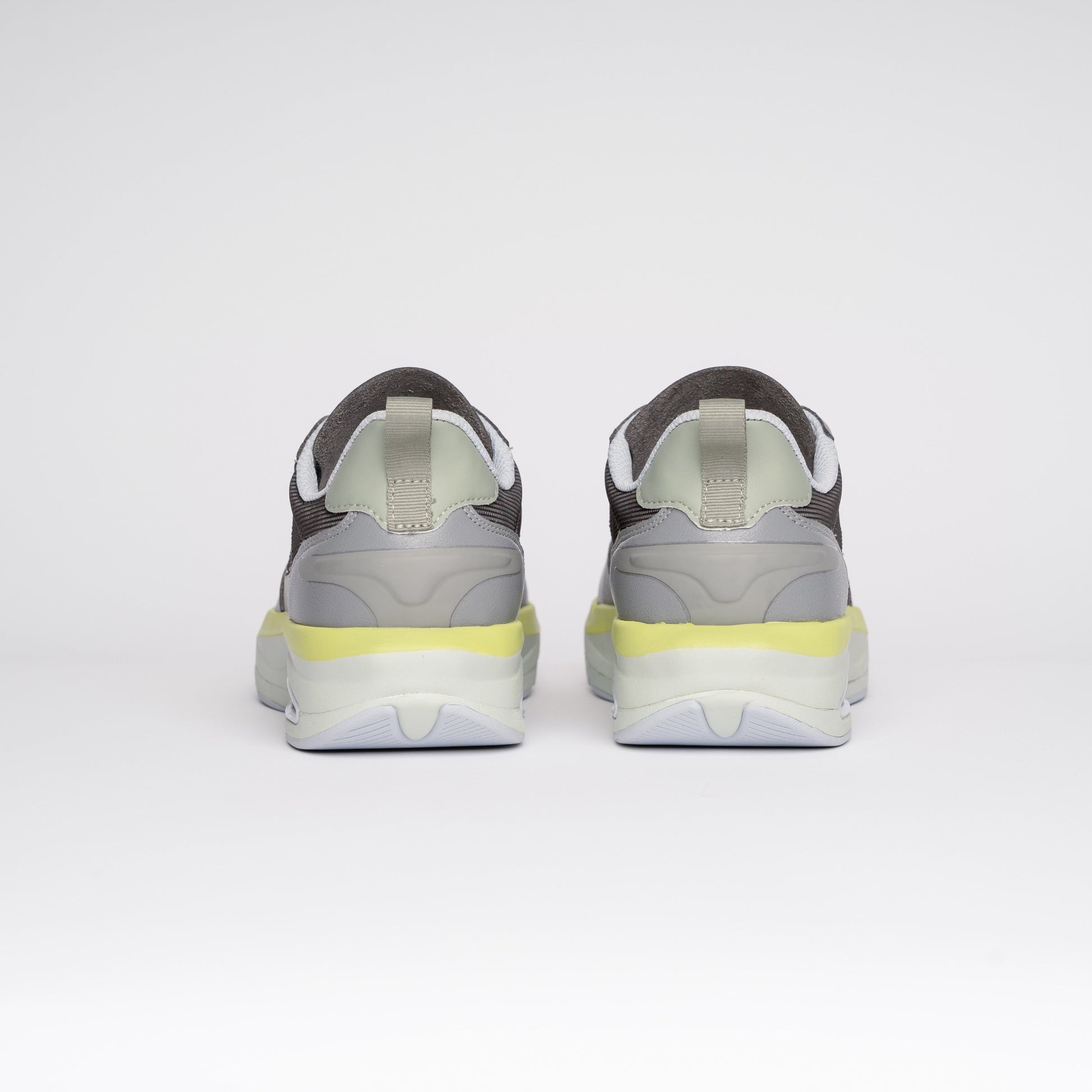 Gray sneakers with yellow accents on a white background