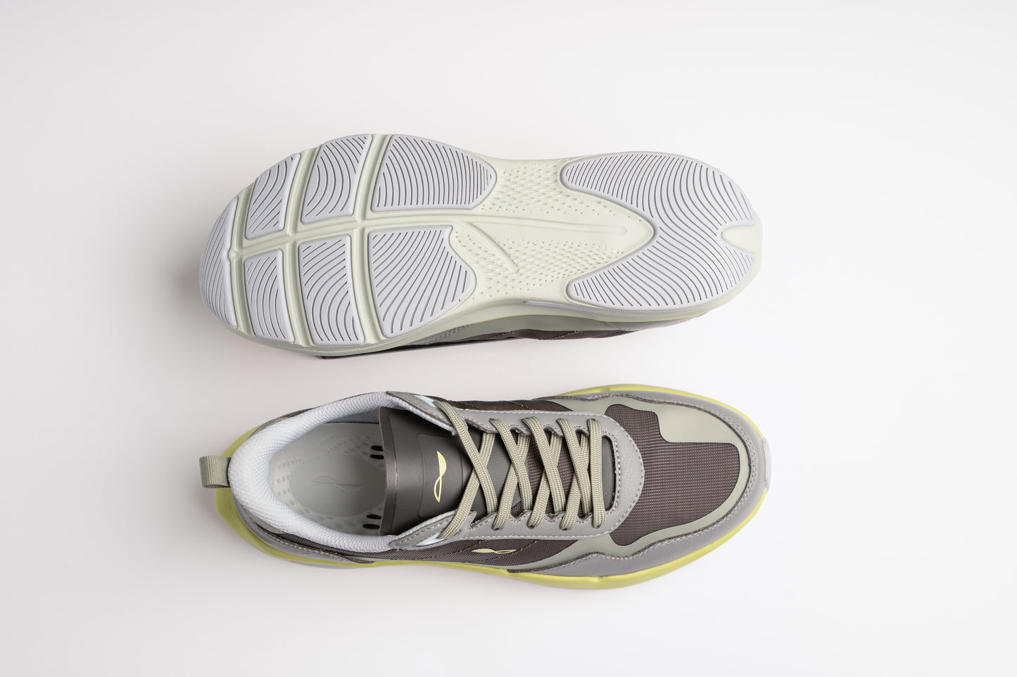 Gray and yellow running shoes shown from top and side on a light gray background