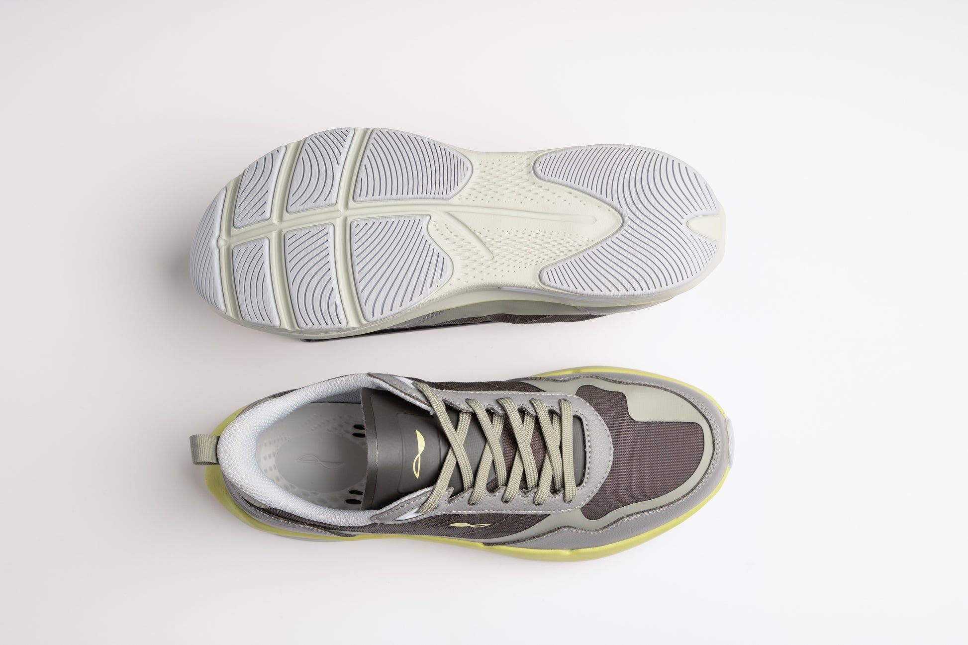 Gray and yellow running shoes shown from top and side on a light gray background