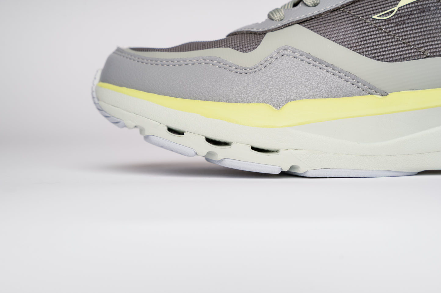 Gray and yellow sneaker on a light gray background